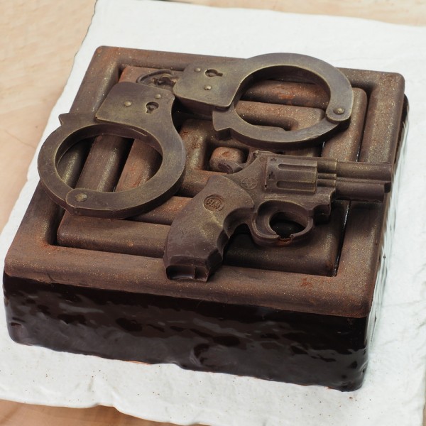 Торт с шоколадными наручниками и пистолетом